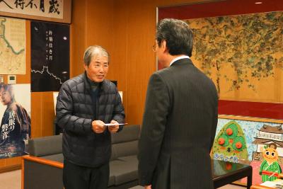 寄附金を受け取る永松市長