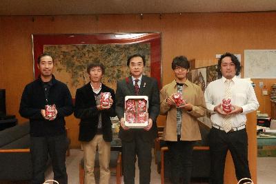 イチゴを持つ永松市長とイチゴ学校卒業生