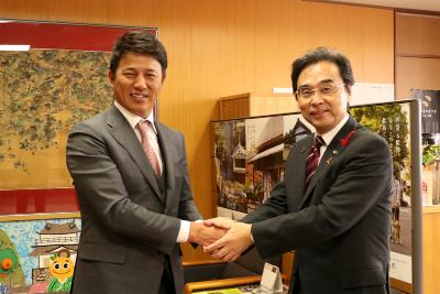 握手をする平石監督と永松市長