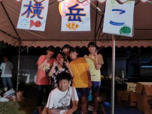 横岳夏祭りのテントの下でピースをしている子供6人の写真